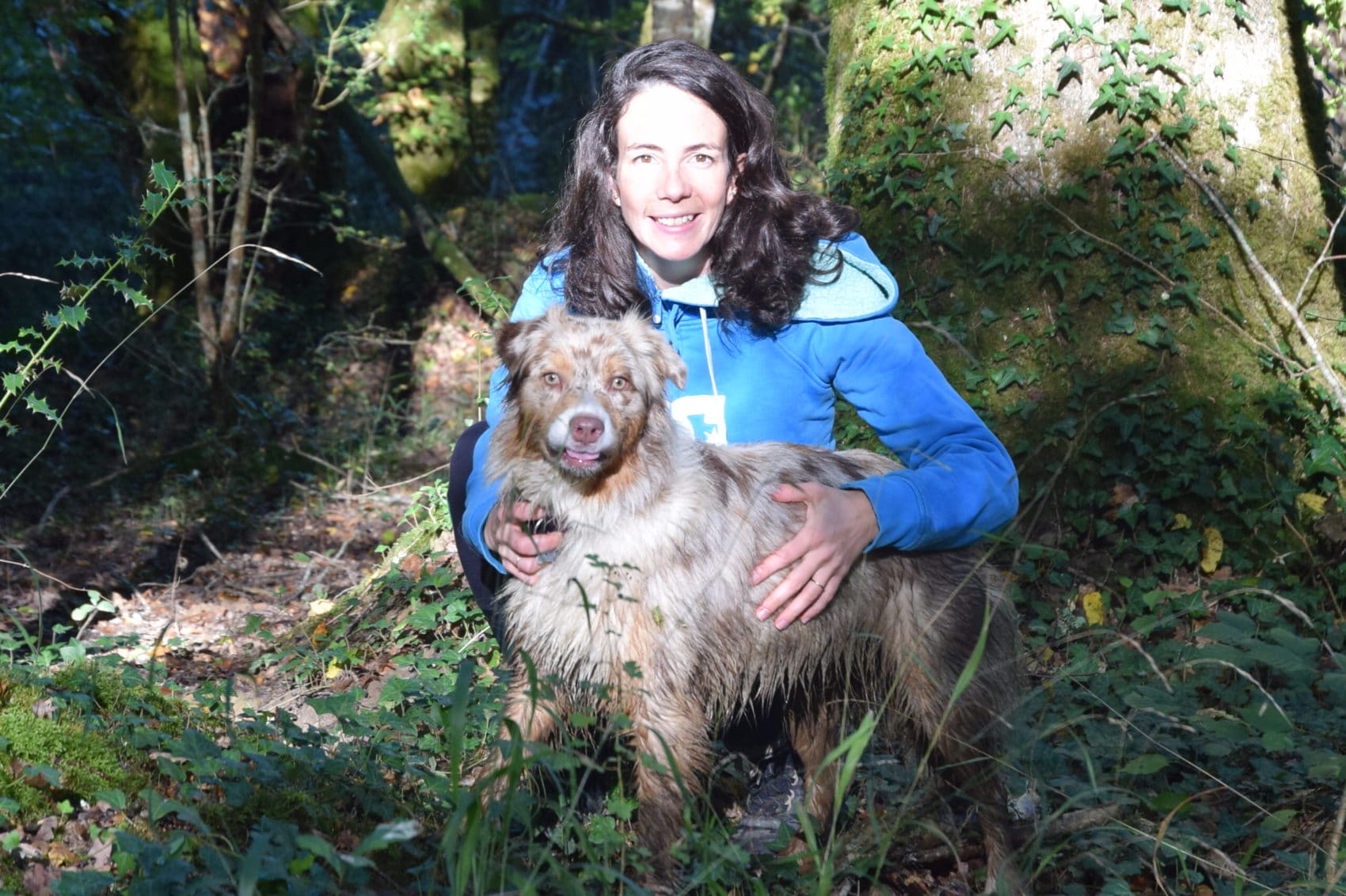 Une femme et son chien dans les bois